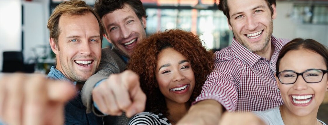 Gruppe von Menschen zeigt auf Bildbeobachter*in