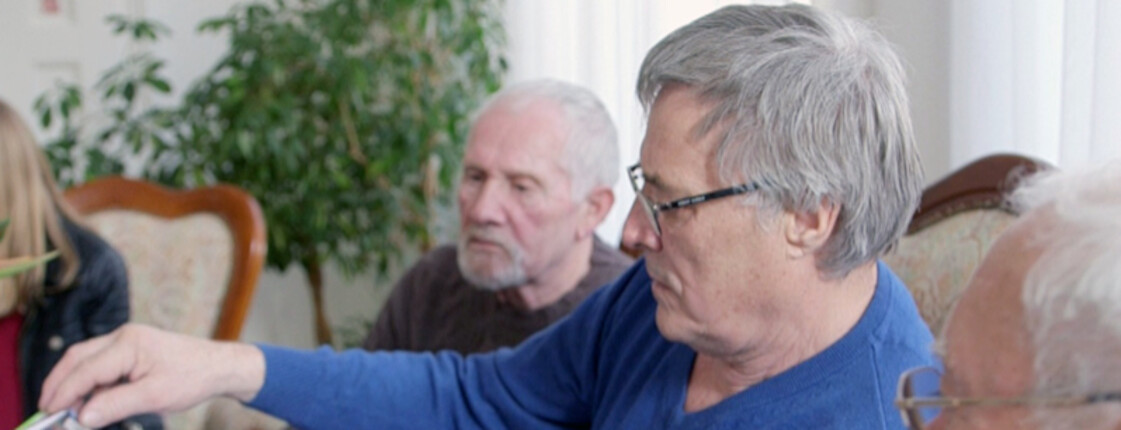 Drei Männer schauen Fotos an